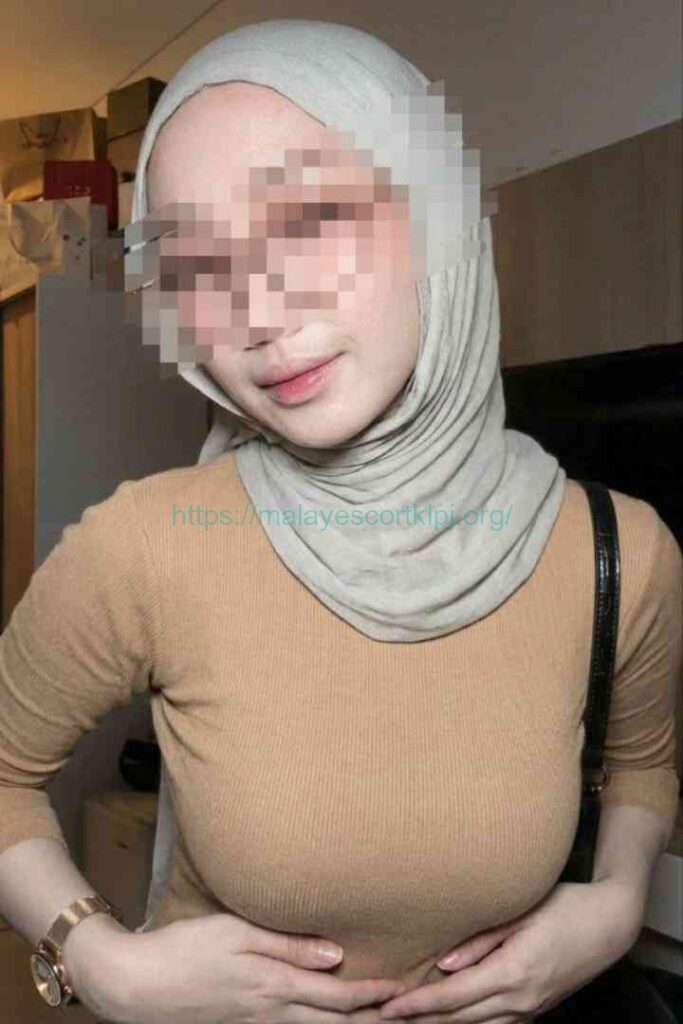 Kesya wearing a tan long-sleeve shirt and a light grey hijab